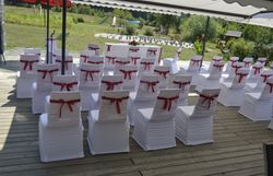 Festlich geschmückte Stühle auf einer Terrasse im Freien