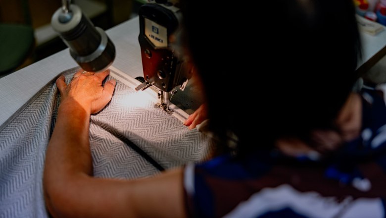 Person n&auml;ht Stoff mit N&auml;hmaschine.