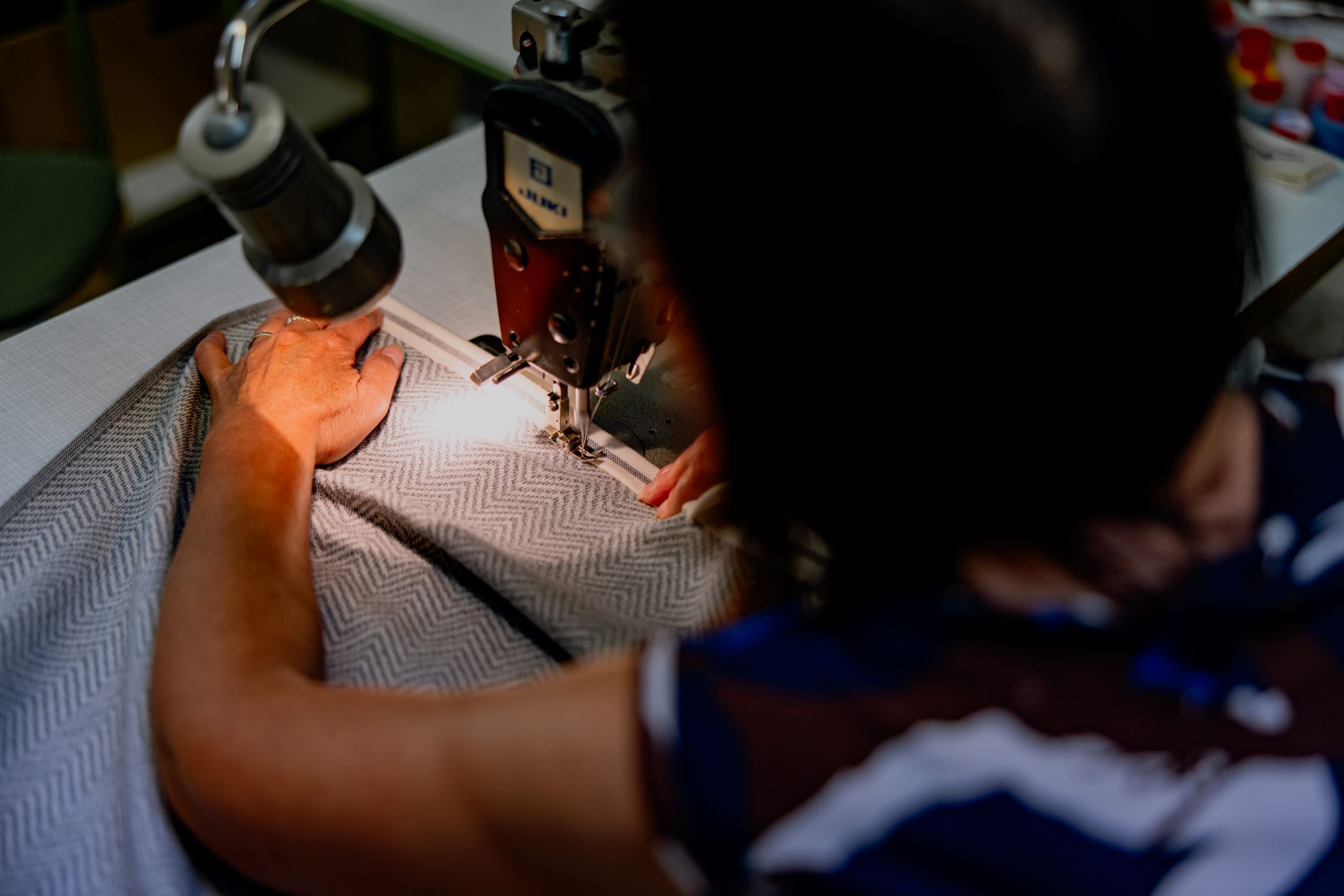 Person näht Stoff mit Nähmaschine.