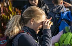 Ein Mädchen schaut durch ein Mini-Fernglas