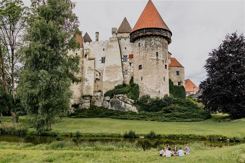 Burg Heidenreichstein mit Menschen auf einer Wiese im Vordergrund.