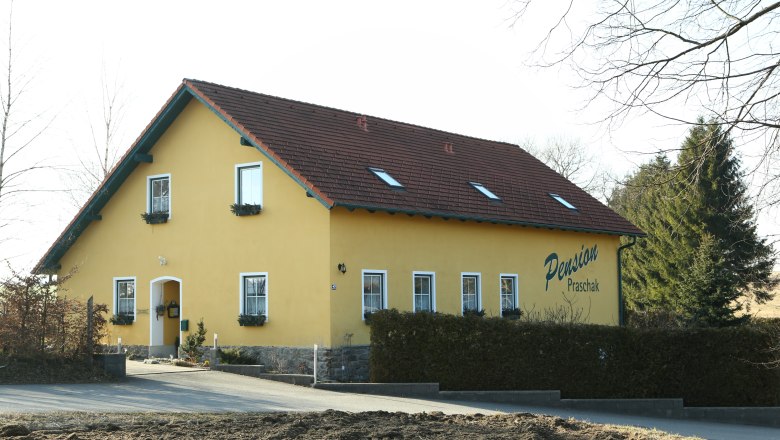 Gelbes Gebäude mit der Aufschrift 'Pension Praschak'.