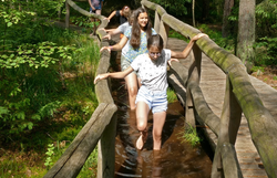 Kinder gehen barfuß und mit kurzen Hosen durch den Schlamm